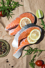 Salmon. Raw Trout Red Fish Steak served with Herbs and Lemon. Cooking Salmon, sea food. Healthy eating concept