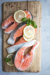 Salmon. Raw Trout Red Fish Steak served with Herbs and Lemon. Cooking Salmon, sea food. Healthy eating concept