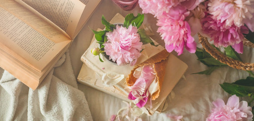 Still life details in home interior of living room. Cup with Pions flowers and spring decor on the books. Read, Rest. Cozy spring concept.