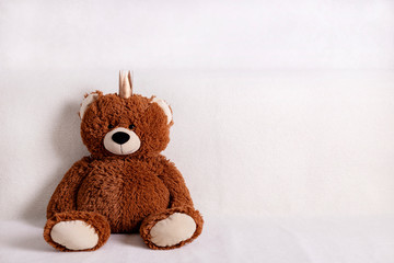 Children's toys - bears of brown and beige color with golden little crownsс are sitting on the sofa. Selective focus.