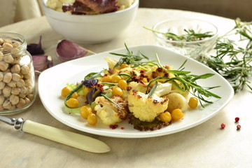 Roasted cauliflower with chickpeas, zucchini noodles and rosemary, salad