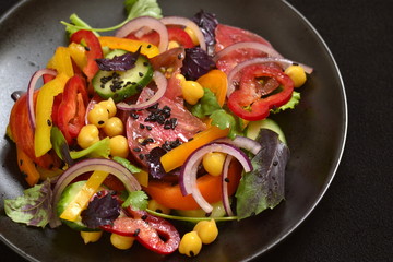 Salad with chickpeas, fresh vegetables and black sesame, copy space