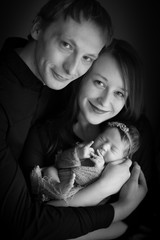 Parents hug their newborn daughter