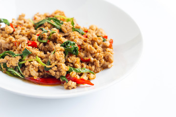 Stir-fried hot and spicy pork with basil on white.