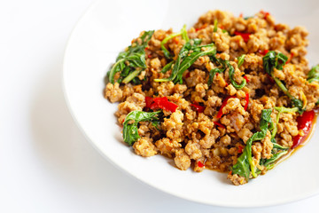Stir-fried hot and spicy pork with basil on white.