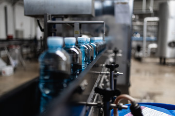 Fototapeta premium Bottling plant - Water bottling line for processing and bottling pure mineral carbonated water into bottles.