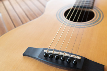 Fototapeta premium Acoustic guitar on a wooden background with copy space.The guitar is a fretted musical instrument that usually has six strings.