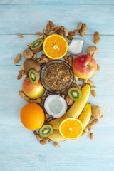 Healthy vegan raw foods on blue background. Fruits and nuts with honey on the table. Natural organic sweet dessert.