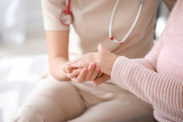 Obraz na płótnie Canvas Doctor with senior woman in nursing home, closeup