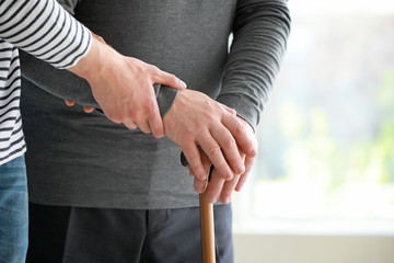 Male caregiver with senior man in nursing home, closeup