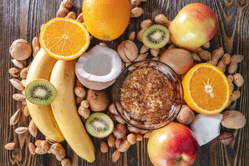 Healthy vegan raw foods on wooden background. Fruits and nuts on the table pile. Natural organic sweet dessert