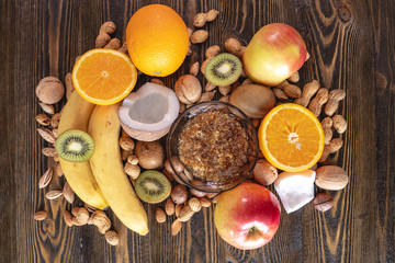 Obraz na płótnie Canvas Healthy vegan raw foods on wooden background. Fruits and nuts on the table pile. Natural organic sweet dessert