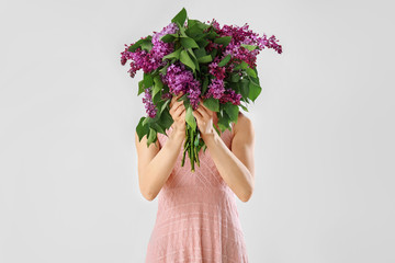 Beautiful young woman with bouquet of lilac flowers on white background © Pixel-Shot