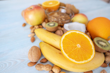 Healthy vegan raw foods on blue background. Fruits and nuts with honey on the table. Natural organic sweet dessert.