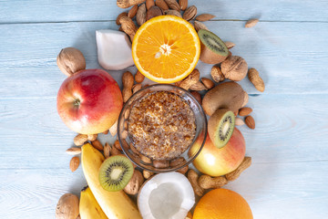 Healthy vegan raw foods on blue background. Fruits and nuts with honey on the table. Natural organic sweet dessert.