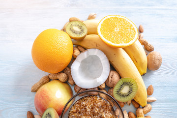 Healthy vegan raw foods on blue background. Fruits and nuts with honey on the table. Natural organic sweet dessert.