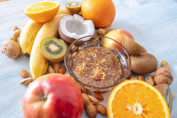 Healthy vegan raw foods on blue background. Fruits and nuts with honey on the table. Natural organic sweet dessert.