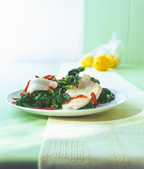 Fried fish fillet of Turbot with spinach on a plate