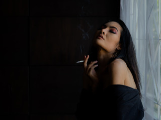 Obraz premium Asian women in lingerie are smoking in the house