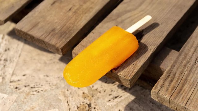 Time lapse of a ice lolly melting on a hot summer day. The popsicle melts in high speed showing the concept of heat waves and the rising temperatures of climate change.
