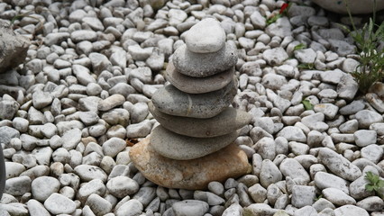 Steine gestapelt zu einer Steinpyramide im Garten