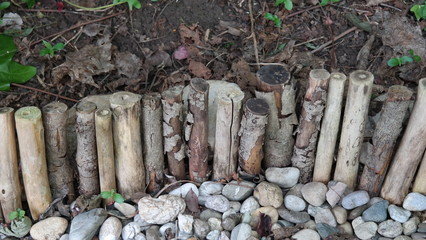 Zaun aus Holz trennt Steine und Erde