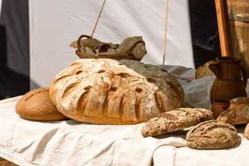 Large loaves of bread on a rustic background on a street counter.