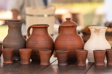 Fototapeta na wymiar Rustic earthenware jug and mugs on wooden table