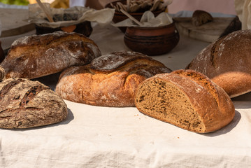 Large loaves of bread on a rustic background on a street counter.