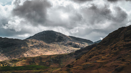 Aerial view over mountains and hills with dramatic sky in Lake District, England