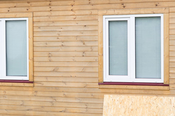 a wooden sheet of plywood for closing the windows lies next to the house