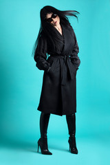 Femme trench et solaire en studio 
