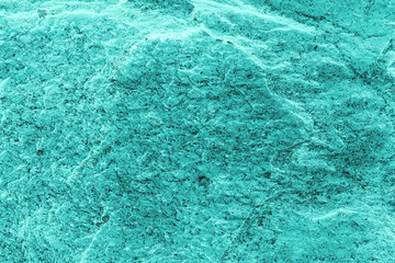 Vintage azure background. Rough painted wall of turquoise color. Imperfect plane of cyan colored. Uneven old decorative toned backdrop of aqzure tint. Texture of teal hue. Ornamental stony surface.
