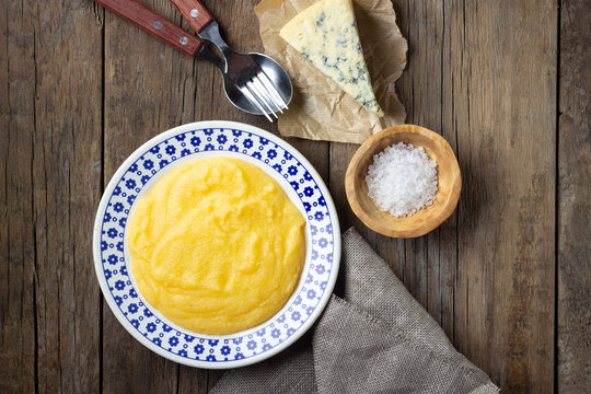 Italian food polenta with cheese gorgonzola on wooden table. Top view.