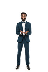 cheerful african american bridegroom holding box with wedding ring while looking at camera isolated on white