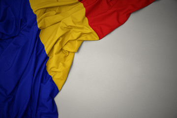 waving national flag of romania on a gray background.