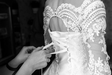 Obraz na płótnie Canvas white lace dress, bride in wedding dress, back view, bride morning, wedding preparation, black and white photo
