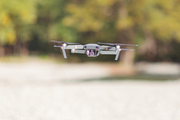 Close up drone with camera. Drone quadcopter in flight on green blurred background
