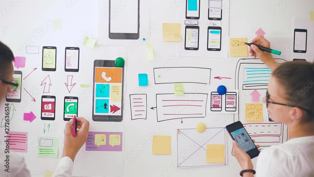 Wall mural designers is developing a web application for mobile phones. woman draws a mockup of interface to sm