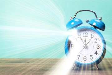 Blue retro alarm clock on wooden table