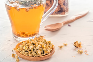 Herbal tea with pharmaceutical chamomile on a white table. Close-up