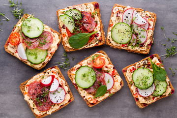 Sandwiches with cream cheese, vegetables and salami.