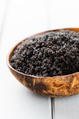 Sea salt in bowl, aroma oil in bottles, Wellness and flowers on grey textured background and flowers on vintage wooden background. Selective focus.