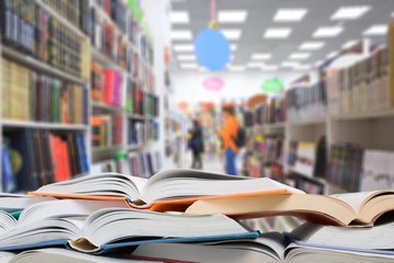 Stack of open school books on library background