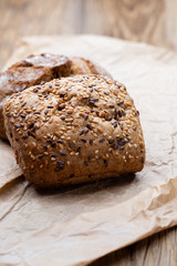 Gold rustic crusty loaves of bread and buns on wooden background. Still life captured from above top view, flat lay.