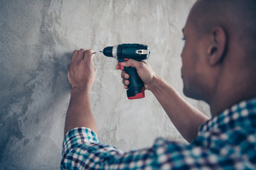 Back rear side cropped view photo of focused professional hold hand diy handmade room apartment eletric machine technician dressed checked shirt casual fashionable clothing  plaid