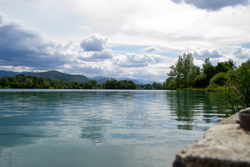 Beautifull cloudy landscape on a lake with reflections and mountains in the horizon