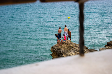 Friends at summer on a rock in front of the sea