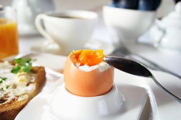 Brakfast table with soft boiled egg. Selective focus