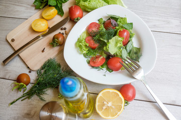Vegetable salad with fresh lettuce, tomatoes and cucumber in clay pot. Top view.